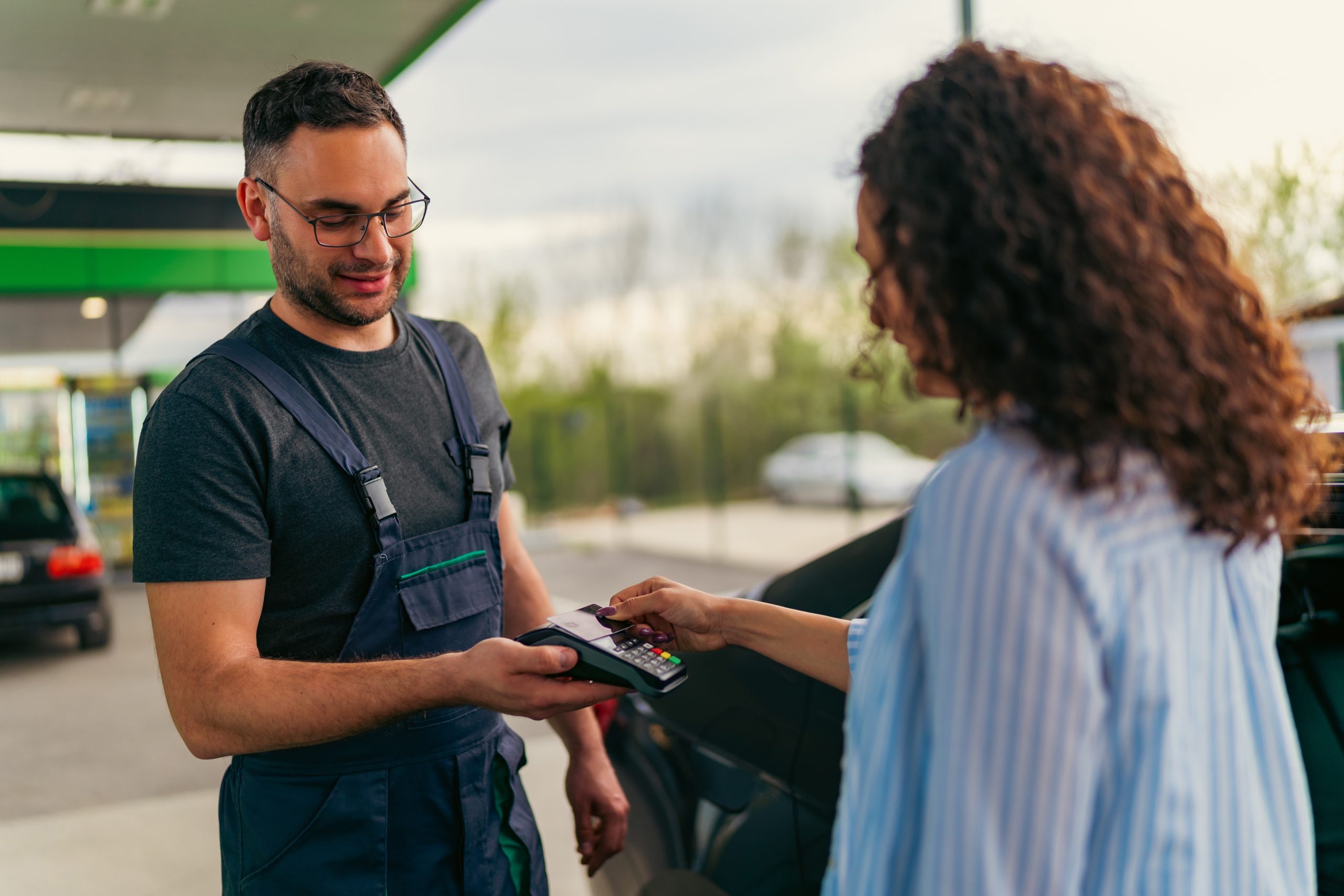 girl paying at a gas station with a point of sale machine